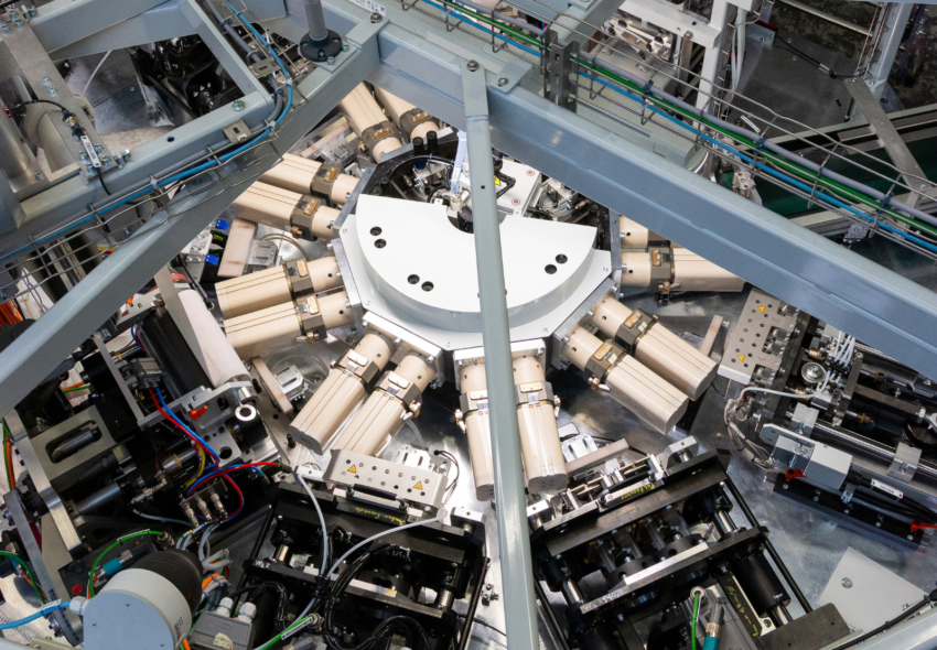 Rotationsrevolversystem für das automatisierte Verschließen und Veredeln von Verbunddosen, das eine präzise Platzierung der Deckel und eine effiziente Massenproduktion gewährleistet.