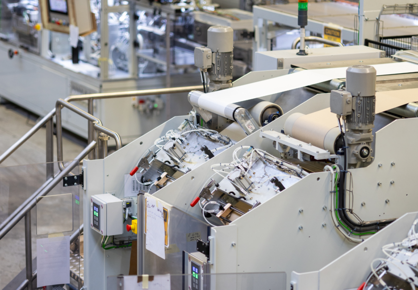 Industrielle Produktionsmaschinen zur Verarbeitung von Karton und Verpackungsmaterialien für die Hochgeschwindigkeitsfertigung von Verbundkanisterkörpern.