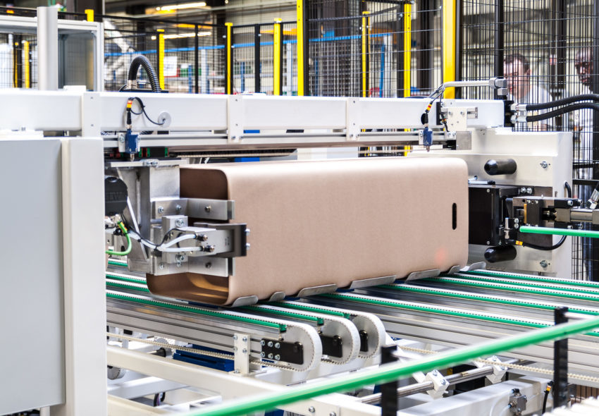 Industrielles Automatisierungssystem zum Stapeln, Transportieren und Verpacken von Faserfässern, die in der Schüttgut- und Industrieverpackungsbranche zum Einsatz kommen.